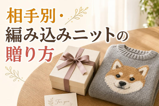 明るいリビングのテーブルに、ラッピングされたギフトボックスと、柴犬の顔が胸に大きく編み込まれたグレーのニットセーターを畳んで並べた俯瞰気味のクローズアップ。ボックスにはくすみカラーのリボン。手前に小さなグリーティングカードの端が入り、贈り物であることが伝わる。糸で編み込まれた編み目の質感がわかる距離感。柔らかい自然光、清潔感のある温かい色調